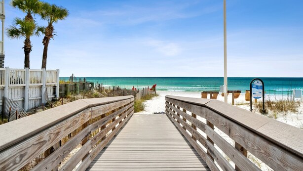 A wooden boardwalk leading to a beach with palm trees and a clear blue sky. - 30a Beach getaway, pool, Save 15% End of Summer (Santa Rosa Beach)