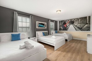 Una camera d'albergo con due letti, un'ampia finestra e un murale sulla parete.