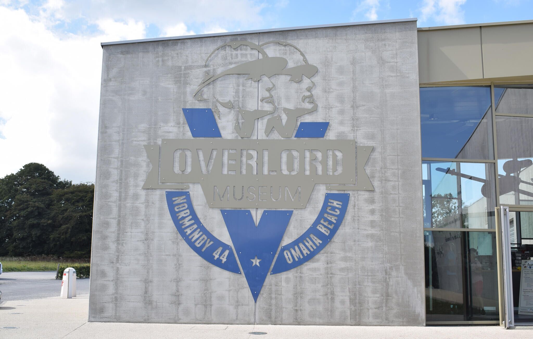 A building with a sign for the Overlord Museum, featuring a logo with a helmet and a star.