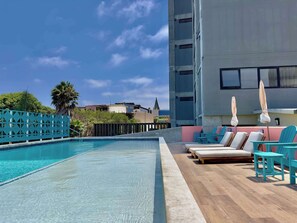 A rooftop pool area with clear blue water, lounge chairs, and umbrellas. - The Wesley Playas de Tijuana Storybook by the sea (Tijuana)