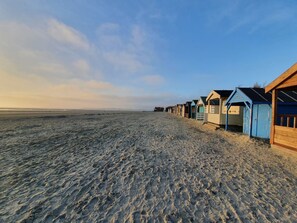 Ein Strand mit aneinandergereihten Holzstrandkörben.