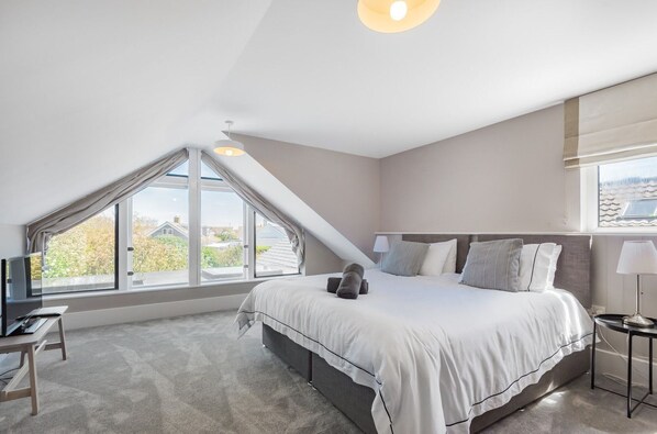 A bedroom with a large bed, a desk, and a window with a view of the outside. - Sleeps 10 | Beach House 200m from Sea | Walk to East Wittering (West Wittering)