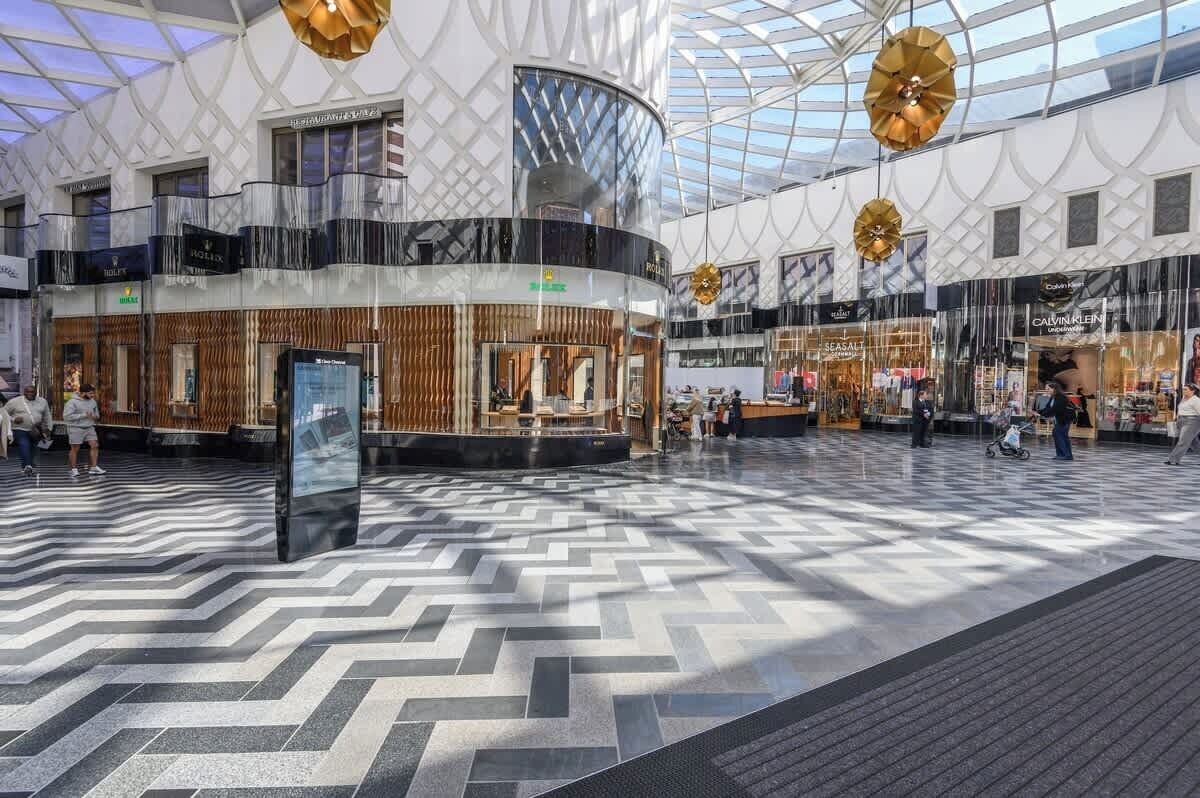 Un vaste atrium doté d’un haut plafond et d’un motif géométrique sur le sol.
