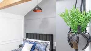 Een slaapkamer met een bed, een hangplant en een hanglamp.