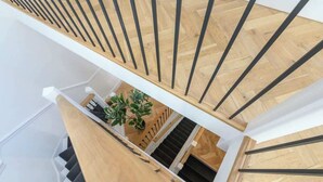 Een modern interieur met een houten trap en een witte muur.