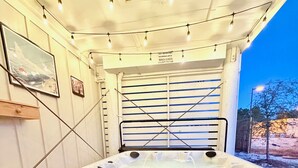 A hot tub with a wooden bench and steps, surrounded by string lights. - Walk To Beach, Private Hot Tub, Pool, Firepit, Sleeps 12, 3BR Summer Salt Home (Orange Beach)