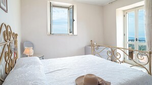 Un dormitorio con cama, ventana y balcón.