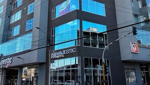 Un hôtel moderne, avec plusieurs étages, de grandes fenêtres et une enseigne bien visible portant le nom « Majestic Hotel ».