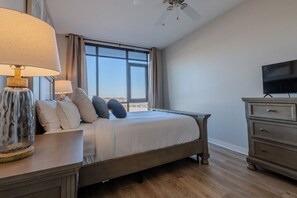A bedroom with a bed, a TV, a lamp, and a view of the city. - Luxurious Downtown High floor Corner-2bd2bth-#420- Parking included (Nashville)