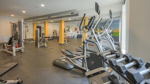 Et fitnesscenter med løbebånd, håndvægte og styrkemaskiner.