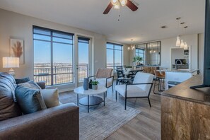 A spacious living area with a balcony, a dining area, and a kitchen. - Luxurious Downtown High floor Corner-2bd2bth-#420- Parking included (Nashville)