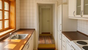 A compact kitchen with a sink, stove, and cabinets. - GBH - Central Skagen Townhouse (Skagen)