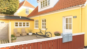 A yellow house with a red roof, a wooden fence, and a mailbox. - GBH - Central Skagen Townhouse (Skagen)