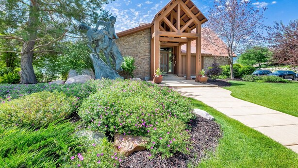A stone building with a wooden porch and a large statue. - Eden Mountain View Retreat: Pool, Hot Tub, Fireplace (Eden)