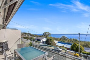 A balcony with a pool, overlooking a residential area with houses and a clear view of the sea. - Wallawa Water Views Family Retreat in Nelson Bay (Nelson Bay)