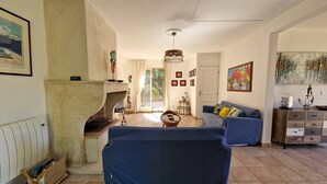 Una sala de estar con chimenea, un sofá, una mesa de centro y un aparador.