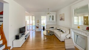 Amplia sala de estar con televisor, sofá, mesa de centro y chimenea.