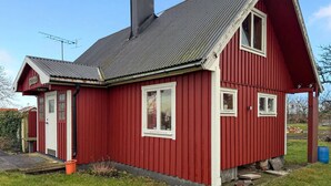 A red wooden house with a sloped roof, a chimney, and a small porch. - 2 bedroom gorgeous home in Borgholm (Borgholm)