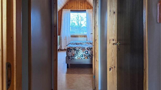 A narrow hallway leading to a bedroom with a bed, a window, and a door. - 2 bedroom gorgeous home in Borgholm (Borgholm)