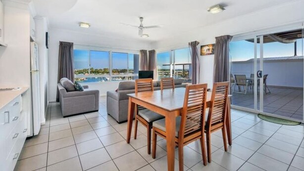 Quarto de hotel moderno com área de refeições, sofá e varanda com vista.