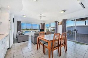 Een moderne hotelkamer met een zithoek, een bank en een balkon met uitzicht.