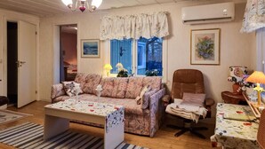 A cozy living room with a patterned sofa, a wooden coffee table, a brown armchair, and a small table with a lamp. - Lovely home in Ljungskile with WiFi (Ljungskile)