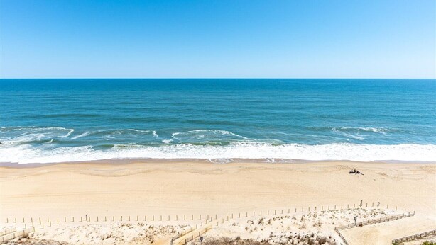 A beach with a clear sky, calm sea, and a sandy shore. - 2 BR Condo w/ Sunrise and Sunset Views (Ocean City)