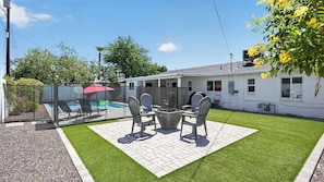 A backyard with a pool, patio furniture, and a white house. - Walk to Old Town - Scottsdale Home with Pool (Scottsdale)