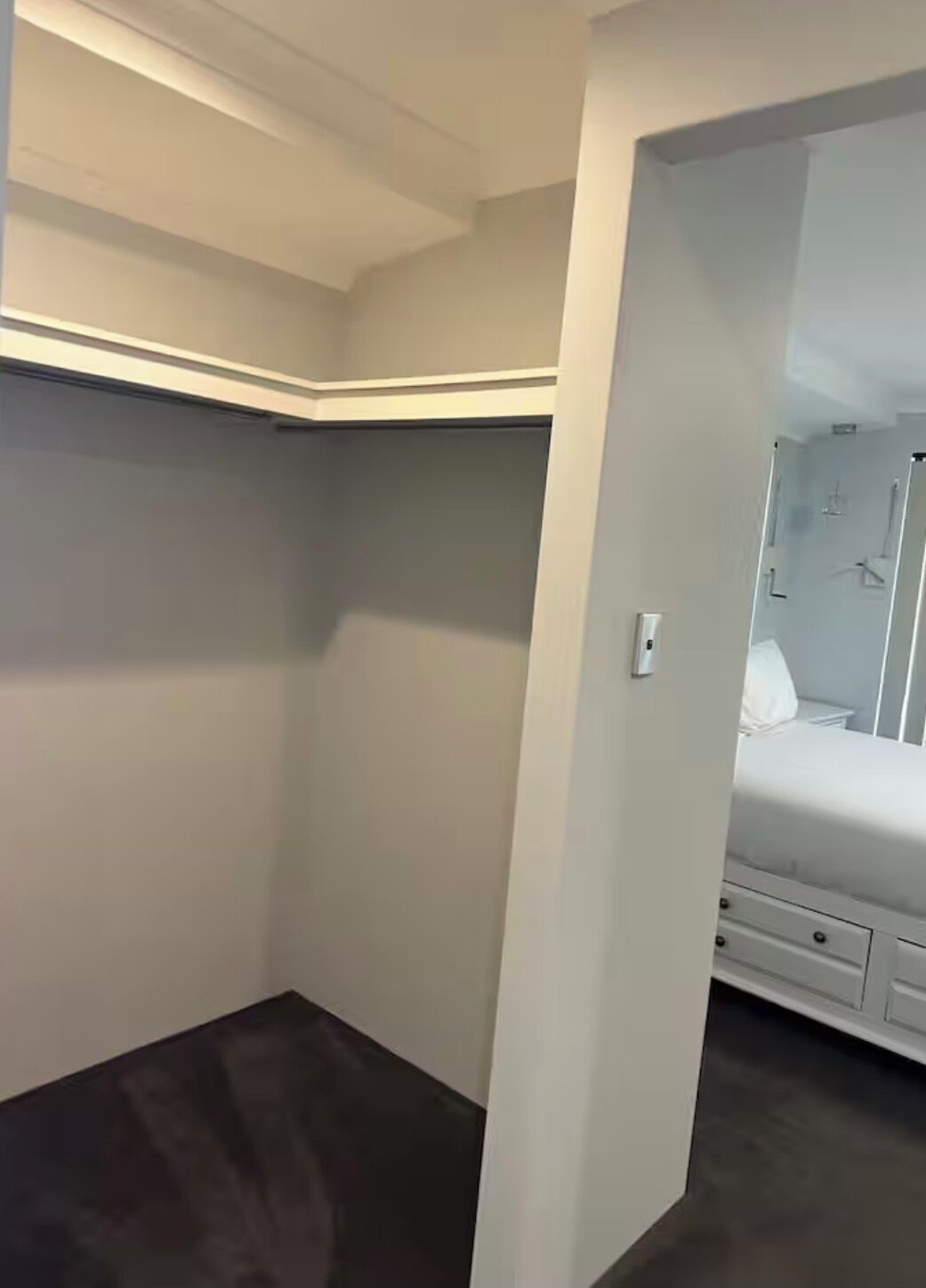 A bedroom with a bed, a dresser, and a closet.