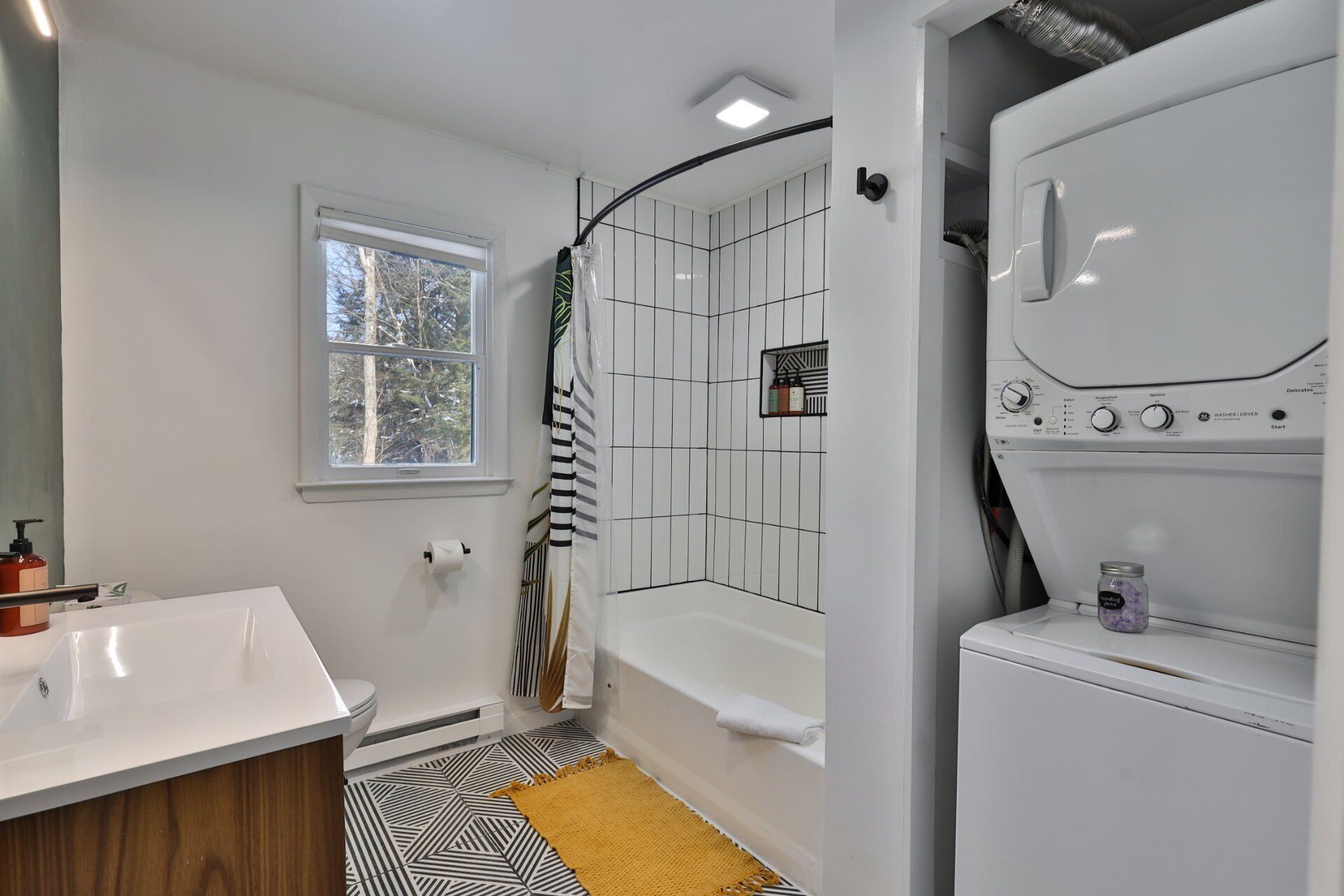 A modern bathroom with a white sink, a bathtub, and a shower area.