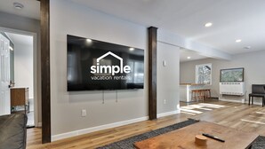 Een moderne woonkamer met een grote flatscreen-tv waarop 'simple vacation rentals' staat.