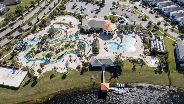 Vue aérienne d’un complexe hôtelier doté d’un parc aquatique, de plusieurs piscines et d’un quai avec des canoës.
