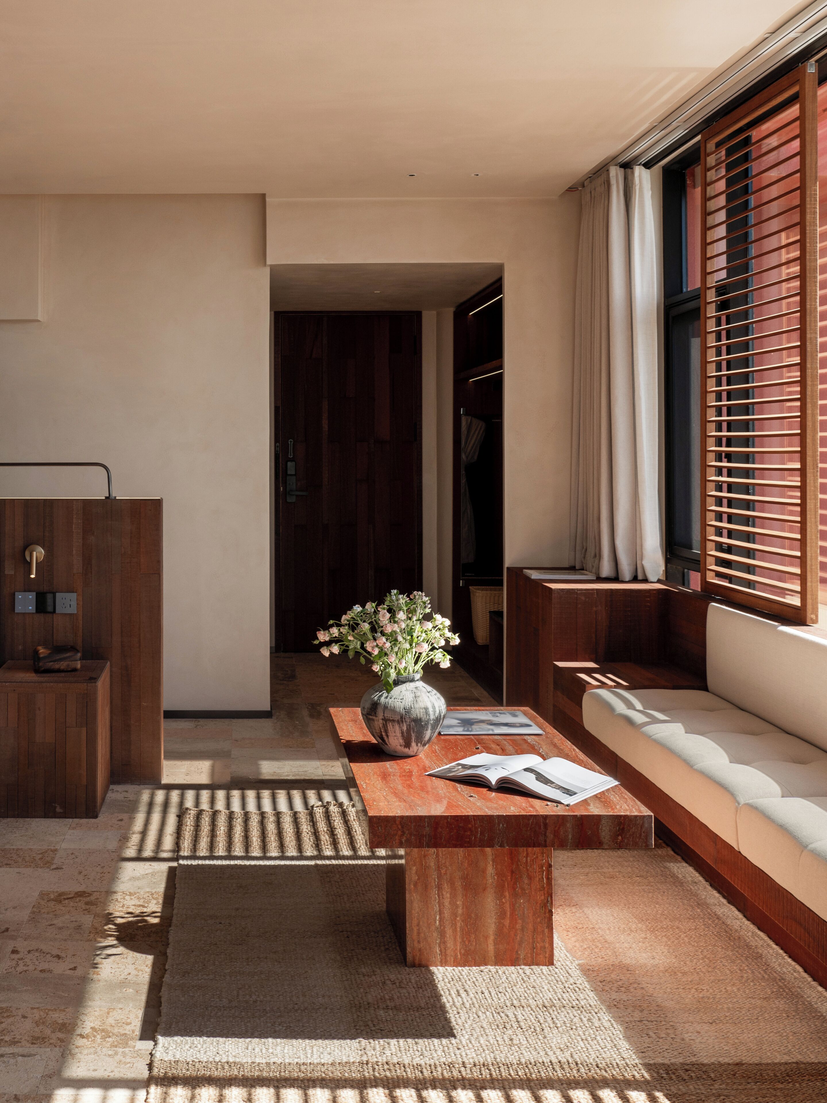Un salon moderne avec une table basse en bois, un vase rempli de fleurs et un canapé.