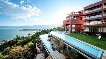 Un hotel moderno con piscina y vistas a un paisaje costero.