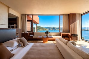 A modern hotel room with a large window offering a view of the sea and hills. - Dayoo Hotel Resort (Dali)