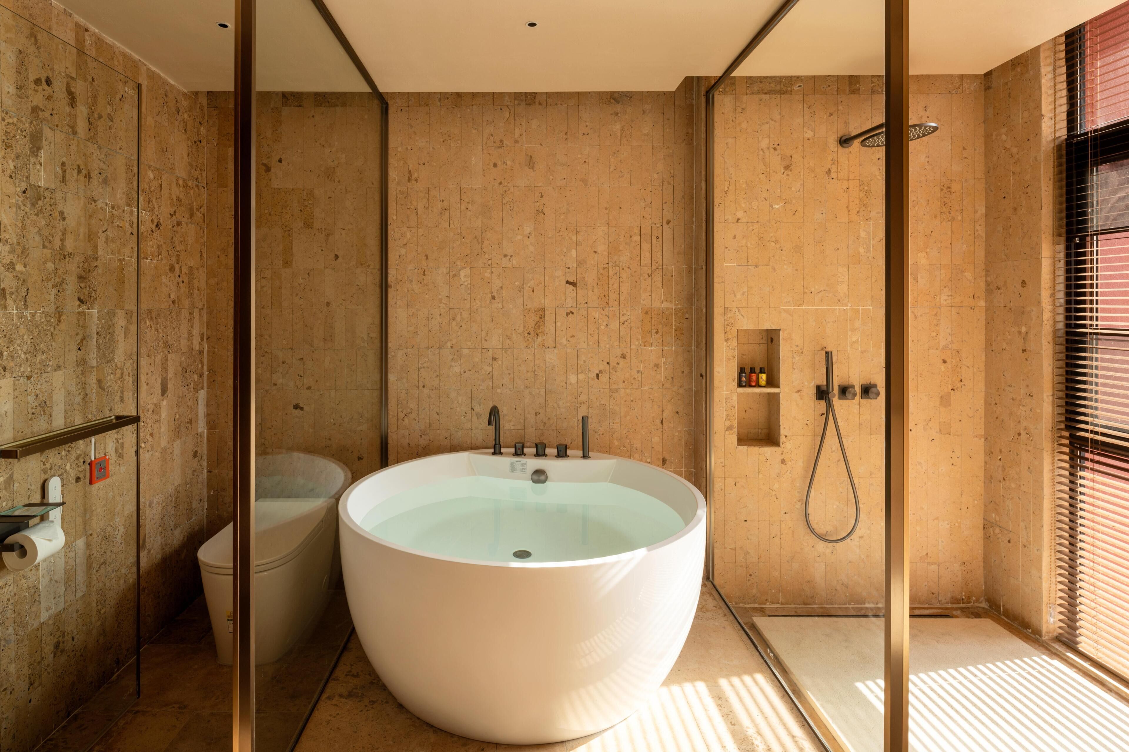 A bathroom with a freestanding bathtub, a shower, and a toilet.
