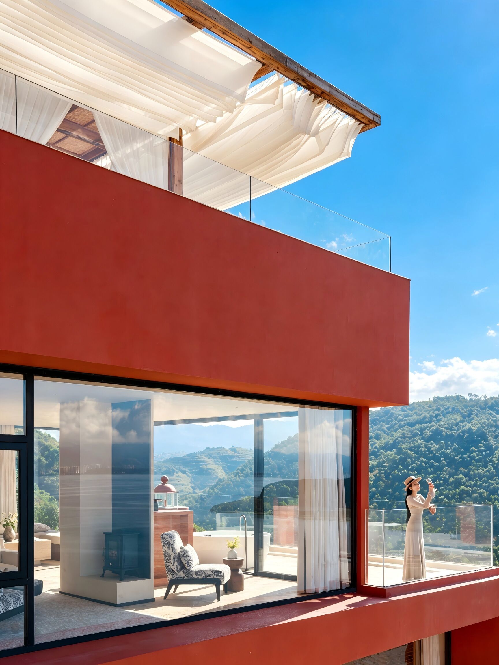 Un edificio moderno con ampie vetrate, facciata rossa e vista su un paesaggio montuoso.