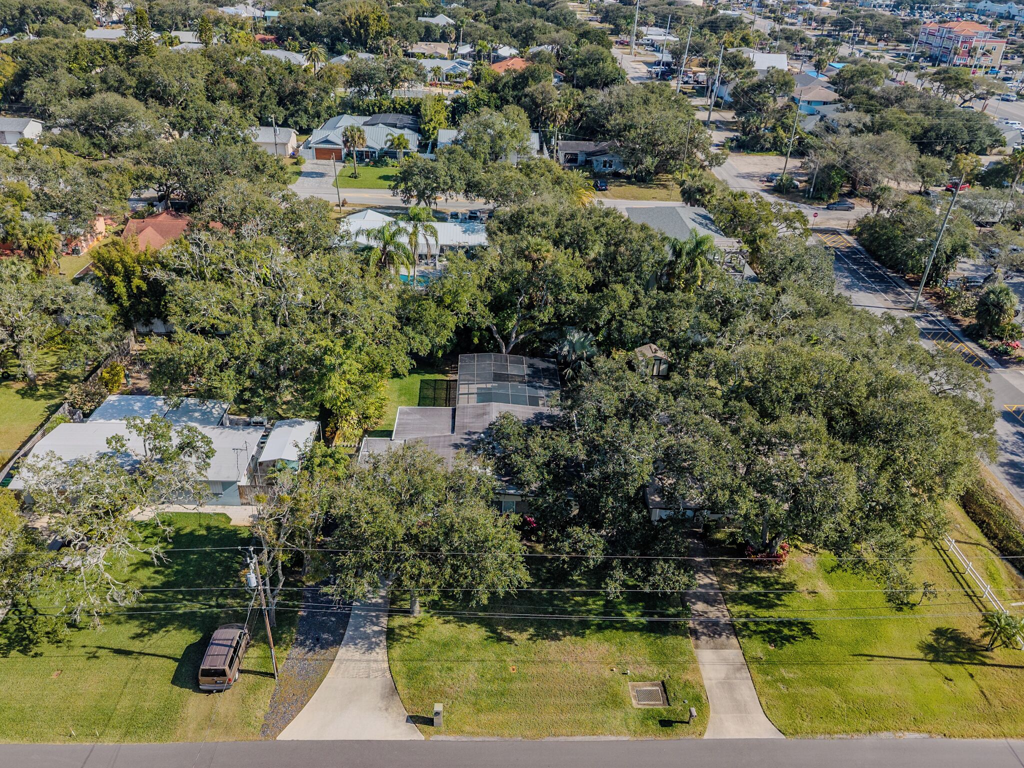 Vista aérea de un barrio residencial con casas, árboles y una calle.