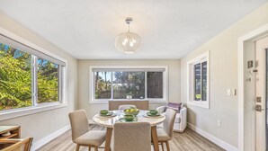 Un coin repas avec une table ronde, quatre chaises et un luminaire suspendu.