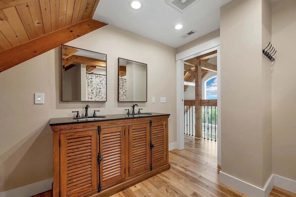 A bathroom with wooden cabinetry, two sinks, and a large mirror. - Spacious Retreat in White Mountains, Views, Privacy and Luxury (Campton)