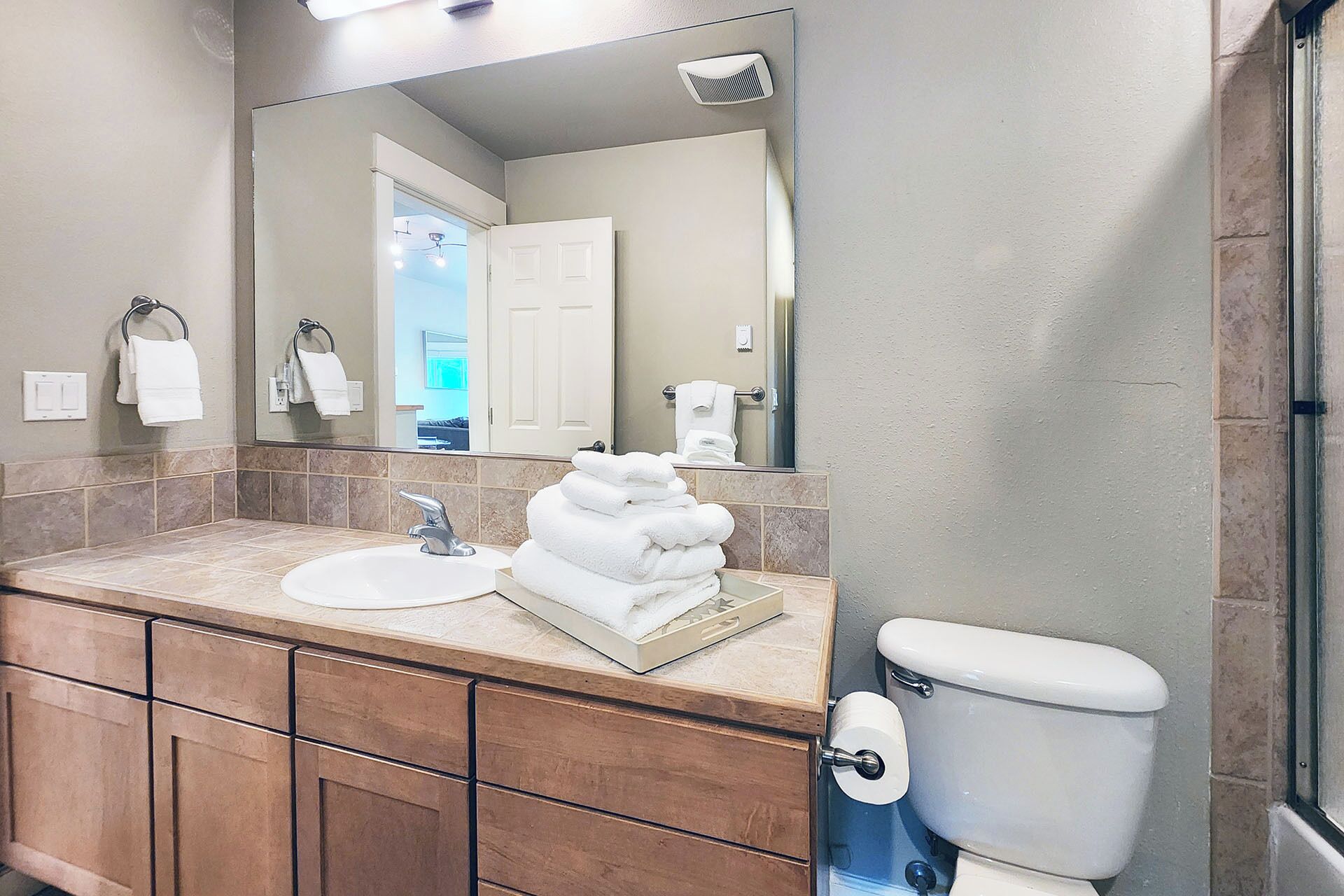 A bathroom with a sink, mirror, towel rack, and toilet.