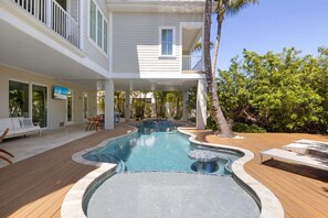 A house with a swimming pool, a balcony, and a patio area. - A Shore Thing: On Canal! Pool Spa!  Rooftop Deck by Anna Maria Life Vacation Rentals (Anna Maria)