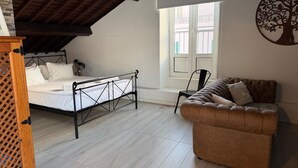 Un dormitorio estilo loft con cama, sofá y ventana con vistas.