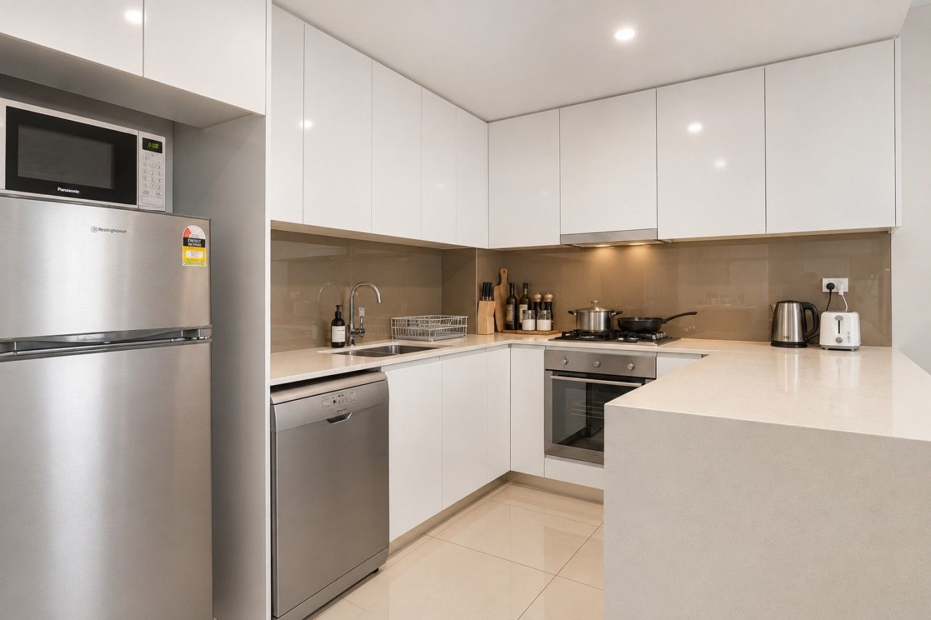 A modern kitchen with stainless steel appliances, a dishwasher, and a built-in oven.