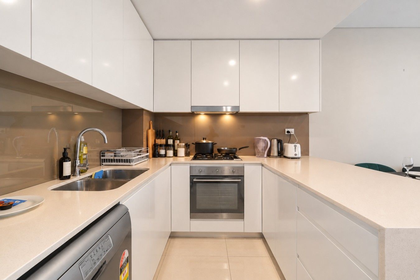A modern kitchen with a dishwasher, stove, oven, and a sink.