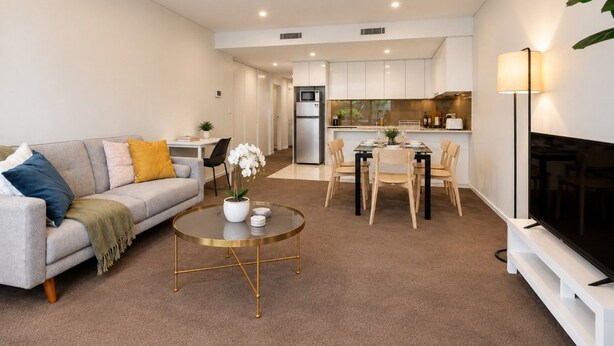 A modern apartment with a living room, dining area, and kitchen.