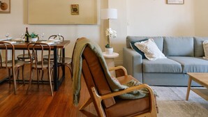 Een gezellige woonkamer met een eetgedeelte, een bank en een tafel gedekt voor een maaltijd.