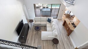 A spacious living area with a sectional sofa, a flat-screen TV, and a dining area with a table and chairs. - 5-Bedroom Villa in Reunion Resort, Orlando Villa 6415 (Orlando)