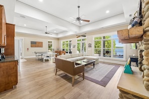 A spacious living room with a sectional sofa, a ping pong table, and a stone accent wall.