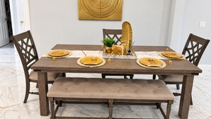 A dining table set with gold plates, a bench, and a decorative wall piece. - Enjoyable 3-bedroom house with pool and AC in charming Jacksonville, Florida. (Jacksonville)